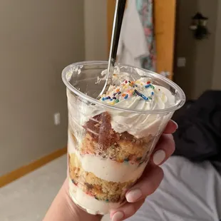 a person holding a cup of cake