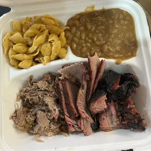 a tray of pulled pork, beans, macaroni and cheese