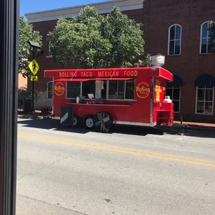 a red food truck parked on the side of the road