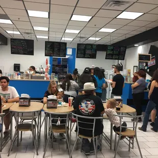 people sitting at tables in a fast food restaurant