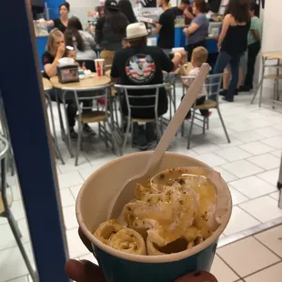 a hand holding a cup of ice cream