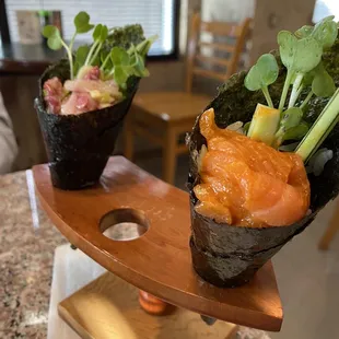 two sushi rolls on a wooden stand