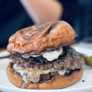 a burger on a plate with pickles