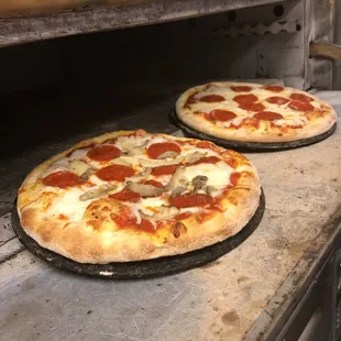 two pizzas cooking in an oven