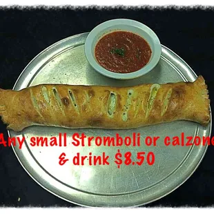 a small bowl of tomato sauce next to a roll