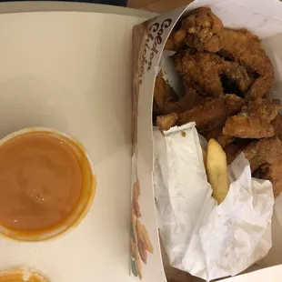 a box of chicken wings and a bowl of sauce