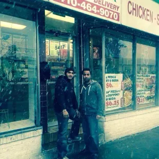 two men standing in front of a store