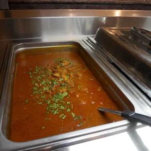 a pan of soup and a serving dish