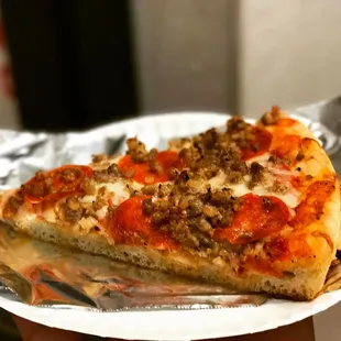 a slice of pizza on a paper plate