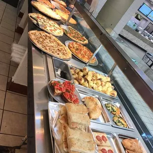 a variety of pizzas on display