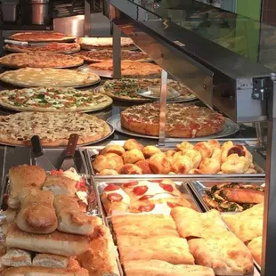 a variety of pizzas on display