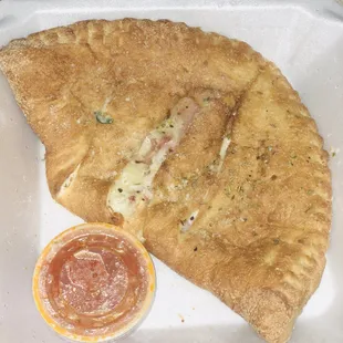 a piece of pizza on a styrofoam container