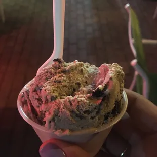 a hand holding a bowl of ice cream