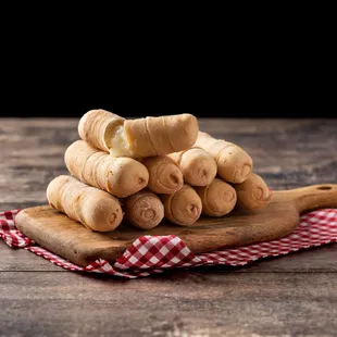 a pile of bread rolls on a cutting board