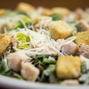 a closeup of a salad with chicken and croutons