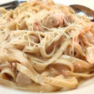 a plate of pasta with shrimp and parmesan cheese