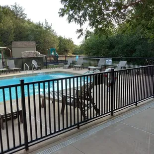 Pool and a playground behind the pool surrounded by trees. A lovely setting.