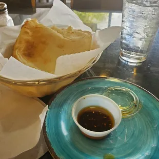 Complimentary warm pita bread and flavored olive oil for dipping.