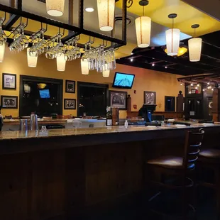 a bar with wine glasses hanging from the ceiling