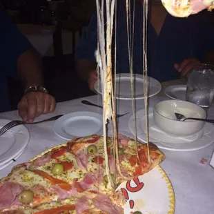 a pizza with olives and ham