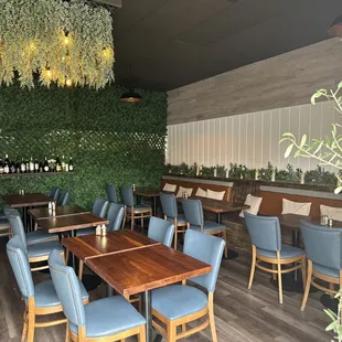 a dining area with blue chairs and wooden tables