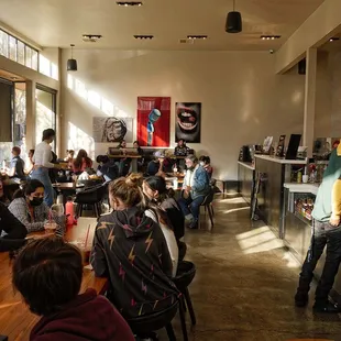 a group of people sitting at tables in a coffee shop
