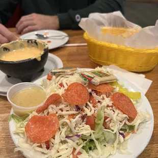 a plate of salad with pepperoni