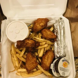 a takeout box filled with fish and fries