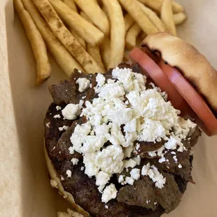 Zeus burger, topped with gyro meat, feta cheese and tomato, with a side of french fries.
