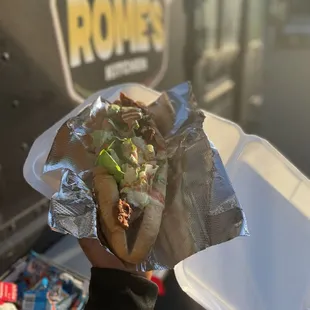 a hand holding a sandwich
