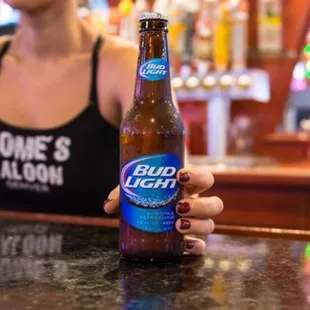 a woman holding a bottle of bud light