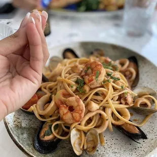 a plate of pasta with shrimp and clams