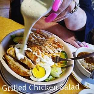 a person pouring dressing on a chicken salad