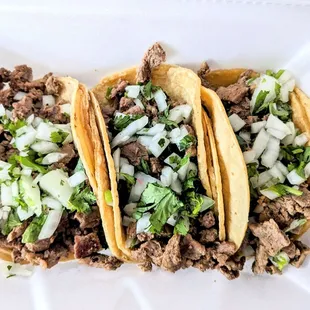 three tacos in a styrofoam container