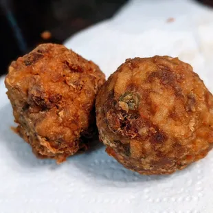 two fried meatballs on a napkin
