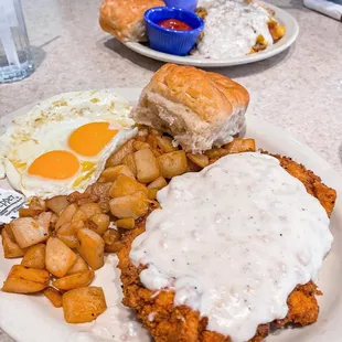 a plate of fried chicken with gravy and potatoes