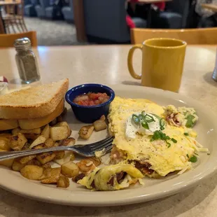 Southern cal omelette. Bacon, tomatoes, and avocado, topped with Jack cheese, sour cream and chives. Served with side of salsa.