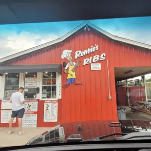 a man standing in front of a red building