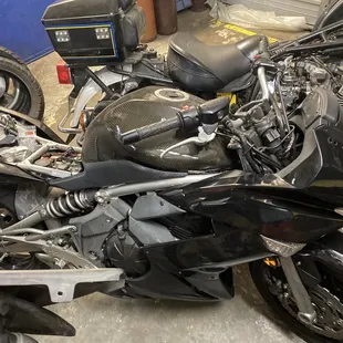 Broken motorcycle in need of windshield seat and mirrors