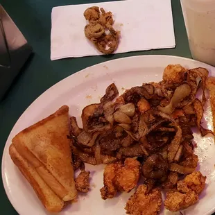Fried chicken with fried onions, and some breaded jalapeños on the side.