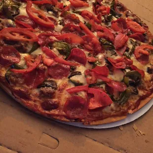 Medium thin crust pizza topped with pepperoni, bell peppers, mushrooms, sausage, tomatoes.