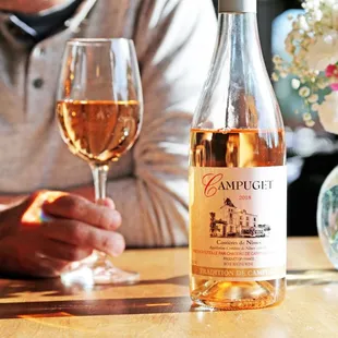 a man sitting at a table with a glass of wine