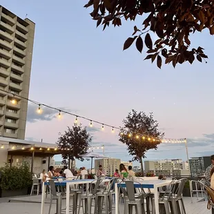 people sitting at tables with string lights