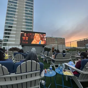 people sitting in lawn chairs watching a movie