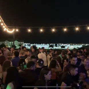 a large group of people at a rooftop party