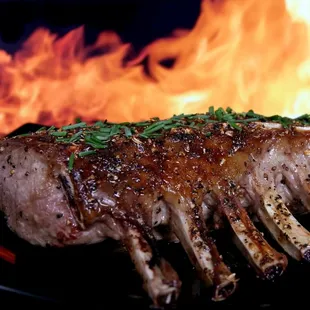 a steak on a grill with flames in the background