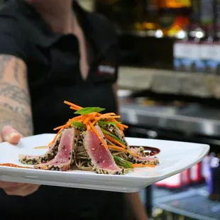 a chef holding a plate of food