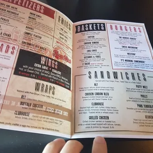 a hand holding a menu
