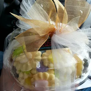 a hand holding a plastic container of candy