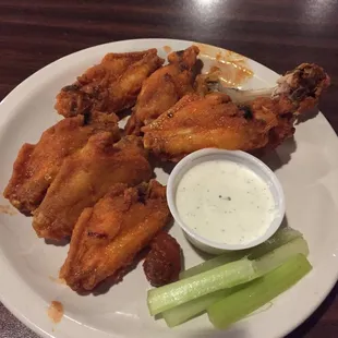 a plate of chicken wings and celery